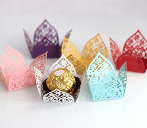 Macro view of laser-cut hollow lace chocolate liners in various pearl paper colors