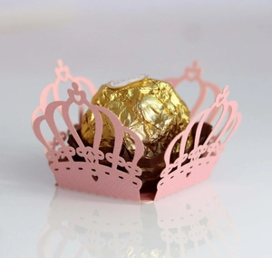 Detailed laser-cut pink crown paper wrapper with hollow heart patterns for party favors