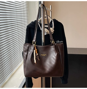 Détail du sac cabas marron café en cuir mat avec perles en bois et logo métallique