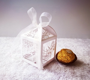 Detail showing laser-cut musical notes and white ribbon bow on a square gift box