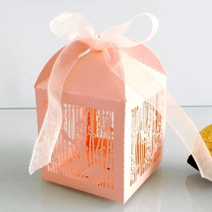 Pink laser-cut party favor box with bird patterns and matching ribbon bow for wedding sweets