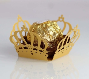 Detailed close-up of golden laser-cut crown lace wrapper for Ferrero Rocher chocolates