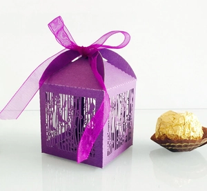 Detail of purple laser-cut candy box featuring hollow tree patterns and ribbon bow