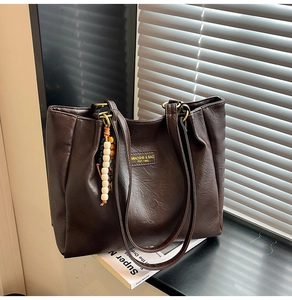 Détail du grand sac cabas marron foncé en cuir PU avec son pendentif en perles
