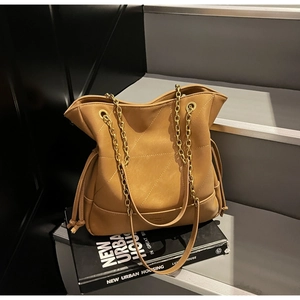 Detail of V-shaped quilted texture and adjustable drawstring on vintage caramel tote bag