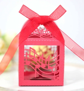 Macro detail of red laser-cut candy box featuring musical notes and a matching organza bow