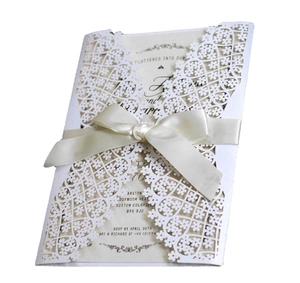 Laser cut ivory wedding invitation set with floral lace sleeve and satin ribbon bow