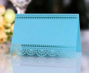Détails de dentelle découpée au laser sur une carte de place de mariage en papier nacré bleu