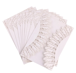 Close-up of laser-cut feather pattern on pearl white wedding invitations with 3D texture