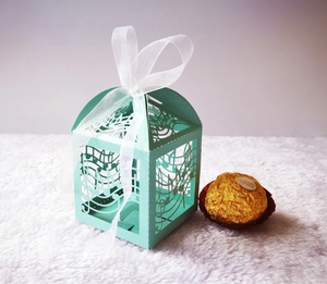 Mint green laser-cut candy box with musical notes and a white chiffon ribbon tie