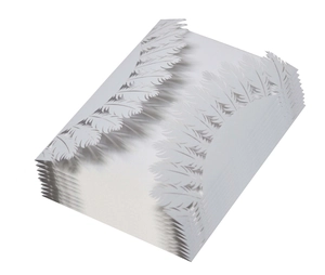 Close-up of laser-cut white pearlescent paper wedding invitation with feather pattern detail
