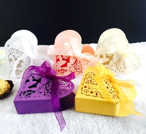 Detail of laser cut heart candy boxes in multiple colors with silk ribbons and floral patterns