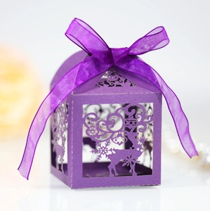 Detail of purple laser-cut Christmas candy box with elk pattern and satin ribbon bow
