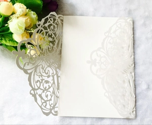Detail of off-white laser-cut wedding invitation with intricate floral lace pattern