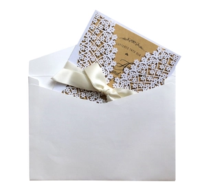 Laser cut white floral wedding invitation set with cream ribbon and kraft paper insert
