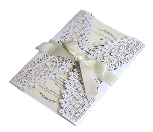 Elegant laser cut floral wedding invitation with cream ribbon and blank inner card