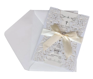Detail of laser-cut butterfly invitation set with white ribbon and cross symbol card