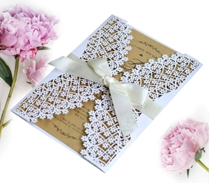 Elegant laser cut white floral wedding invitation card with ribbon and kraft insert