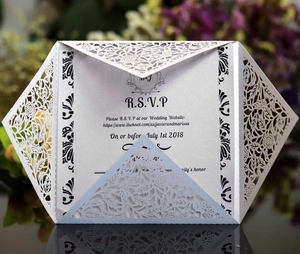 Detailed macro of laser-cut floral patterns on pearl paper wedding invitation card
