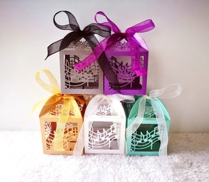 Macro view of laser-cut musical note patterns on shiny pearl paper candy gift boxes