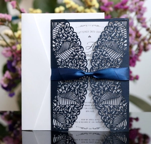 Navy blue laser cut wedding invitation set with white insert and satin ribbon bow