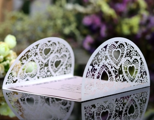 Élégant faire-part de mariage blanc découpé au laser avec motifs de cœurs et fleurs
