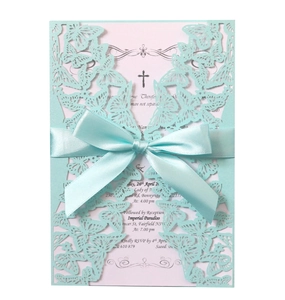Close-up of laser-cut butterfly invitation with Tiffany blue ribbon and cross detail