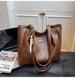 Gros plan détaillé du sac cabas marron texturé avec pendentifs en perles de bois