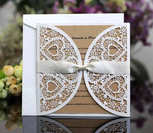 Vue détaillée de l'invitation découpée au laser avec nœud en satin et motifs floraux