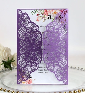 Detail of laser-cut lace floral pattern on deep purple pearl paper wedding invitation