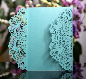 Macro shot of laser-cut light blue wedding invitation sleeve with pearl finish