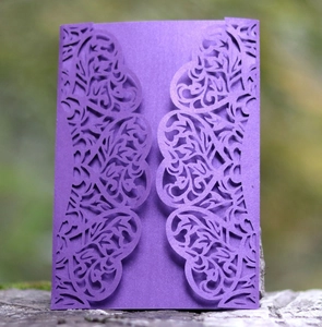 Detailed laser-cut purple pearl paper wedding invitation with floral patterns in nature