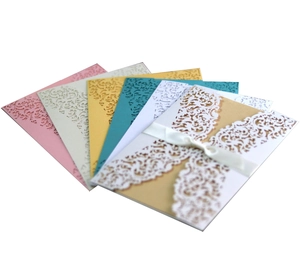 Detailed laser cut floral invitation cards with elegant white ribbon bows in multiple colors