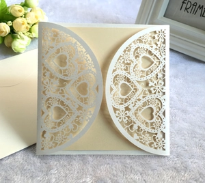 Détail du motif cœur découpé au laser sur carte d'invitation de mariage ivoire élégante