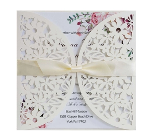 Elegant hollow-out floral wedding invitation with cream envelope and pink ribbon bow