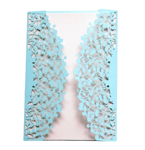 Laser-cut light blue invitation cover with intricate leaf patterns on a white background