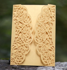 Elegant champagne gold laser-cut wedding invitation with intricate floral lace patterns