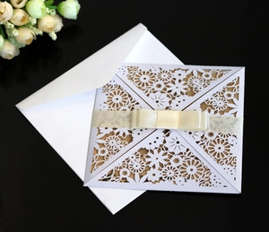 Detailed view of laser-cut floral wedding invitation with silk bow and brown inner card