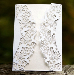 Intricate laser-cut wedding invitation featuring white butterfly and floral lace patterns