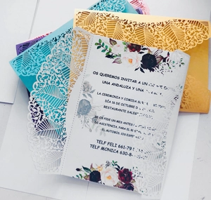 Macro view of laser-cut navy lace invitation envelopes and colorful floral inserts