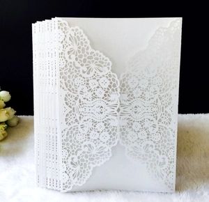 Detailed laser-cut lace floral pattern on white wedding invitation envelope cover