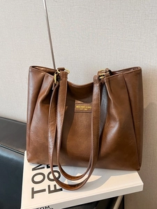 Grand sac cabas en cuir marron avec étiquette MIAOSHE sur un fond de studio élégant