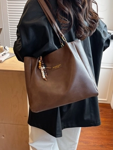 Grand sac cabas marron foncé au design minimaliste avec étiquette vintage et charm