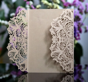 Close-up of laser-cut lace floral pattern on brown kraft paper wedding invitation cover