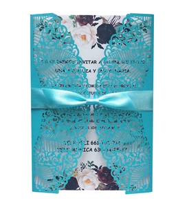 Detail of laser-cut navy blue wedding invitation with satin bow and floral insert card