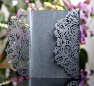 Detailed laser-cut dark purple invitation cover with intricate floral lace patterns