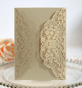 Close-up of laser-cut lace wedding invitation made of shimmering gold specialty paper