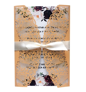 Laser-cut navy blue wedding invitation with floral insert and cream satin ribbon bow