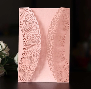 Detail view of laser-cut lace pattern on pink pearlescent paper wedding invitation