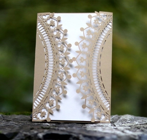 Laser-cut crown floral lace invitation on mossy stone with natural rustic background